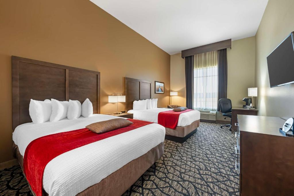 a hotel room with two beds and a flat screen tv at Best Western Plus Lakeview Hotel in Madison