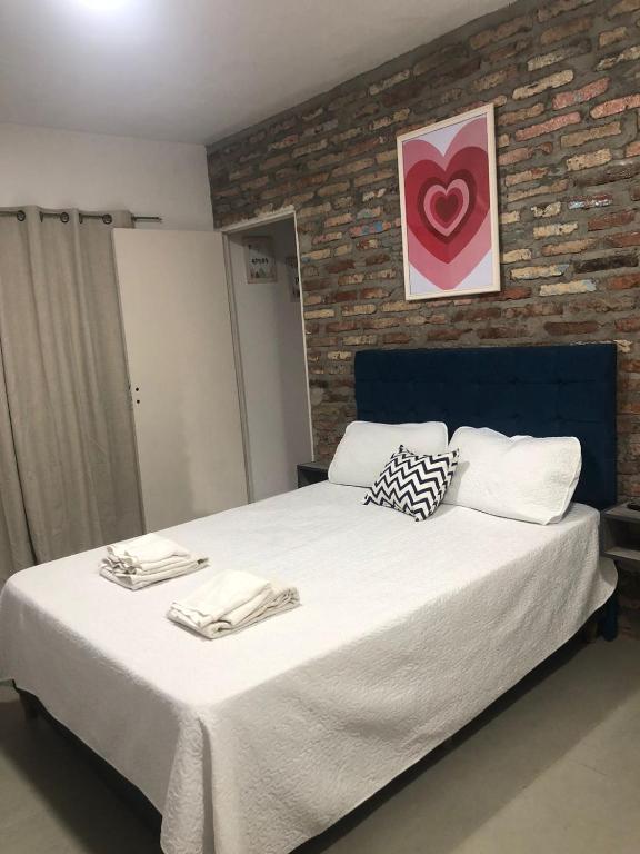 a bedroom with a large bed with a brick wall at Blue Apart in San Miguel de Tucumán