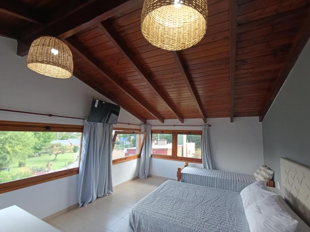 a bedroom with a bed and two lights and windows at Potrero Loft in Potrero de Garay
