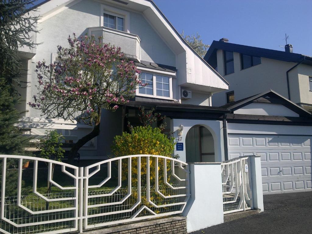 a house with a white fence in front of it at Apartment & Rooms Miboti in Samobor