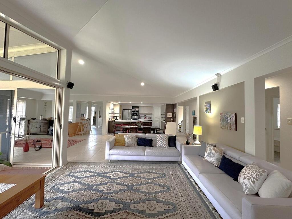 a living room with two couches and a table at Driftwood Dream - Tweed Coast Holidays in Pottsville