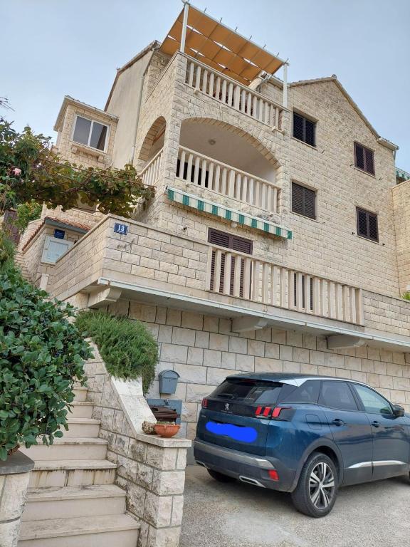 a blue car parked in front of a building at Apartments with parking space Postira, Brac - 700 in Postira