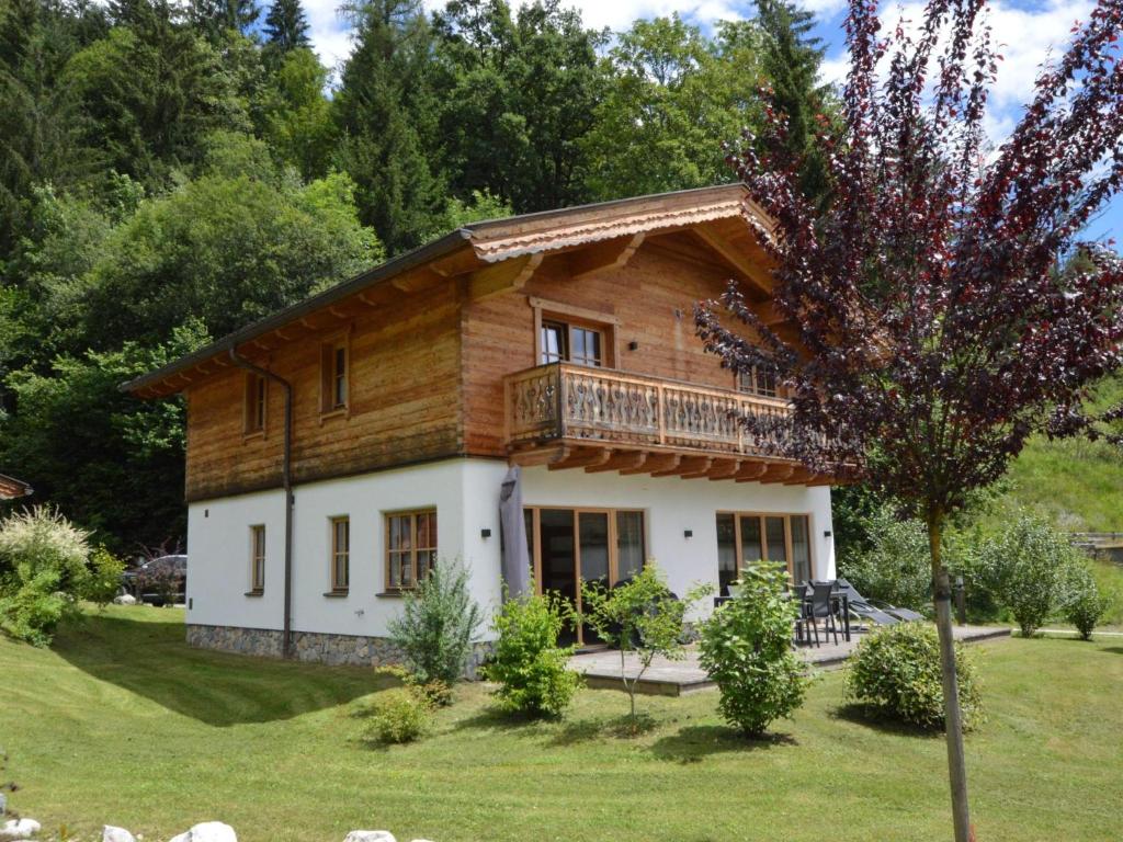 a wooden house with a balcony on a yard at Villa Gradenbach in Haus im Ennstal