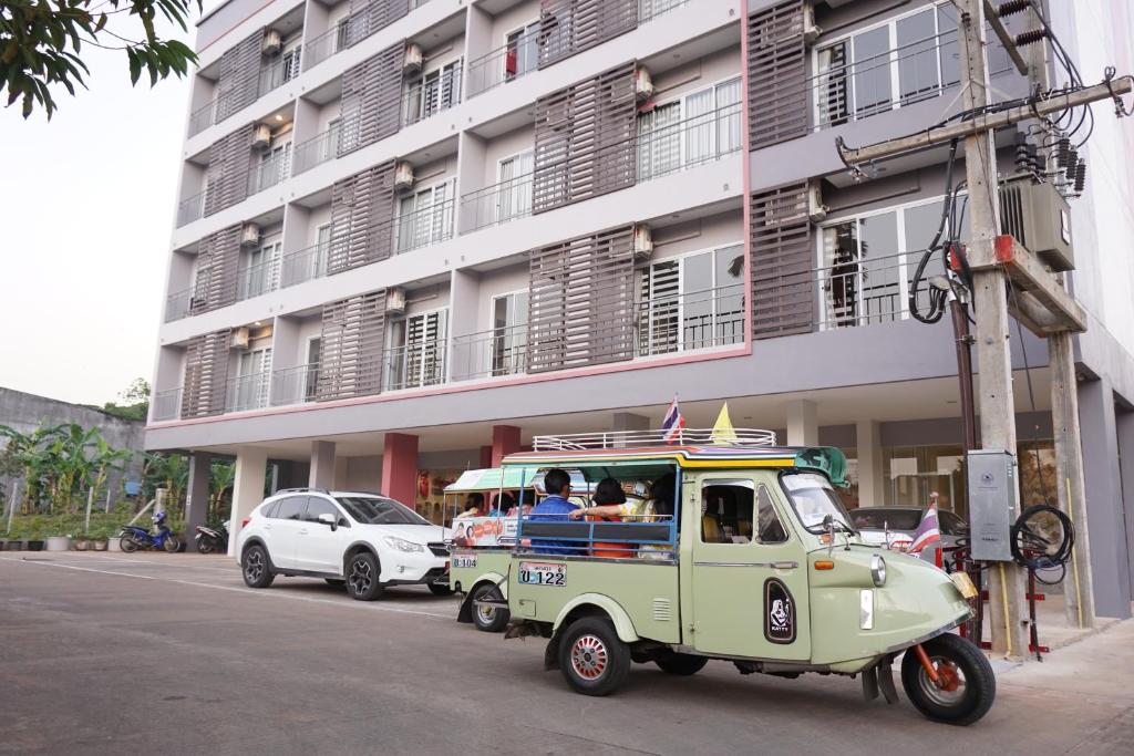een kleine vrachtwagen geparkeerd voor een gebouw bij Chompu Nakarin Apartment in Trang