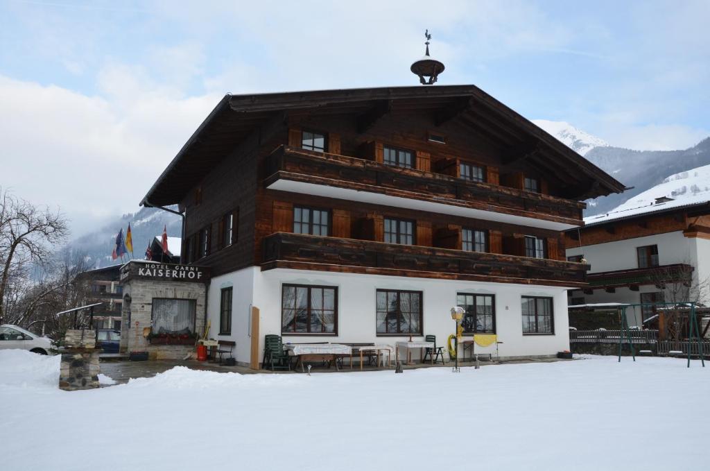 un grande edificio nella neve di fronte di Hotel-Garni Kaiserhof a Rauris