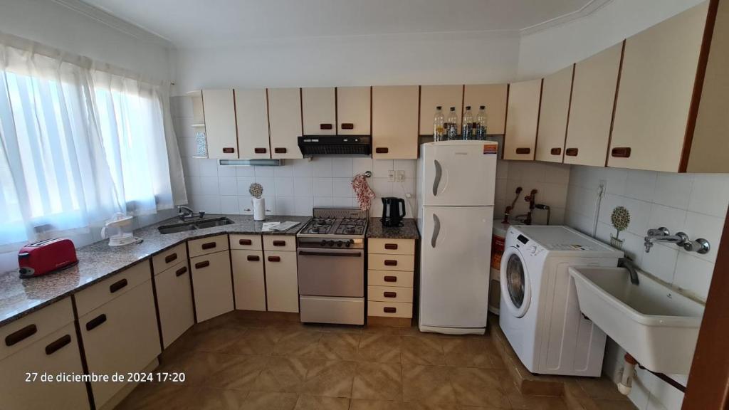 a kitchen with a white refrigerator and a washer and dryer at Avenida Argentina in Monte Hermoso