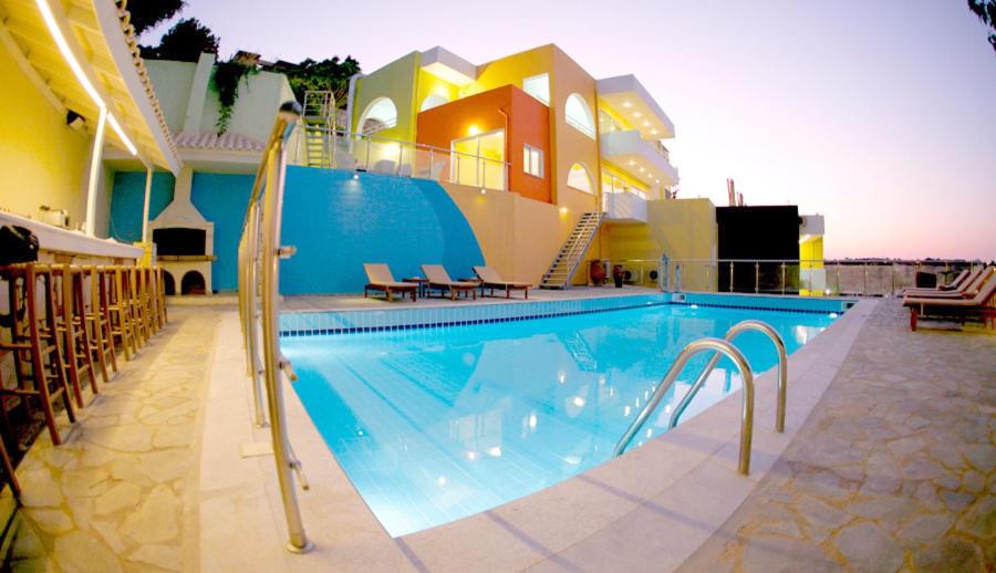 a large swimming pool with chairs and a building at Sunday Life in Agia Pelagia