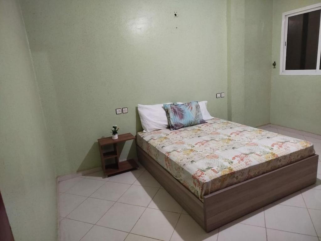 a bedroom with a bed and a small night stand at luxury apartment Ryad zitoune in Meknès