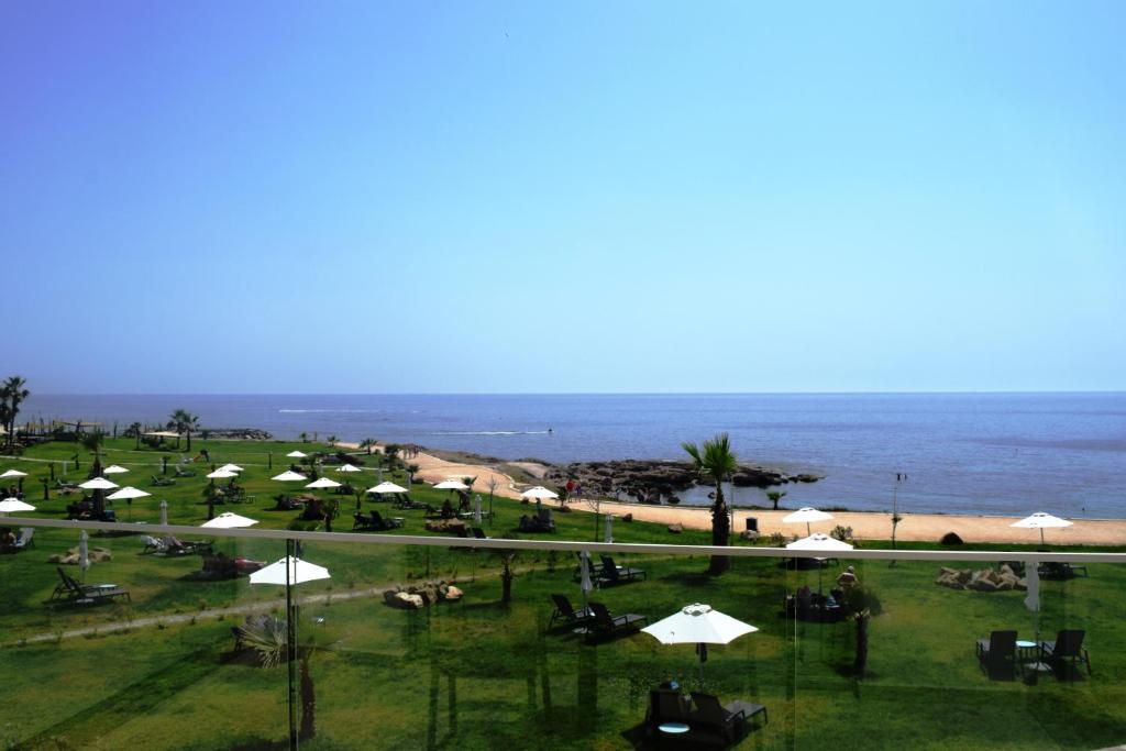 a view of a beach with umbrellas and the ocean at Amphora Hotel & Suites in Paphos