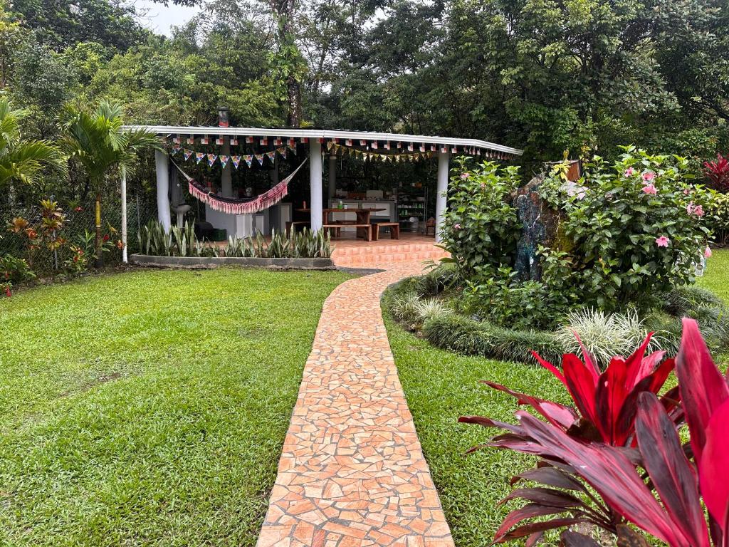 a garden with a brick path leading to a pergola at Hostal Lopez El Valle Cabañas in El Valle