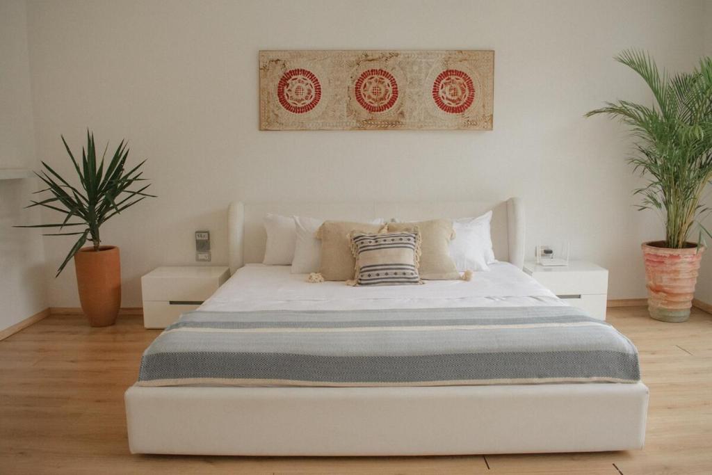 a white bed in a room with two plants at Tulum Casa Xul in Tulum