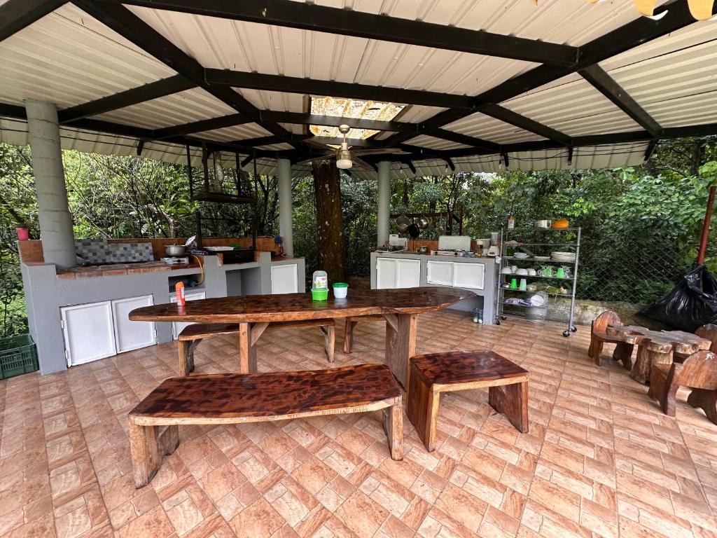 a patio with a table and benches and a kitchen at Hostal Lopez El Valle Cabañas in El Valle