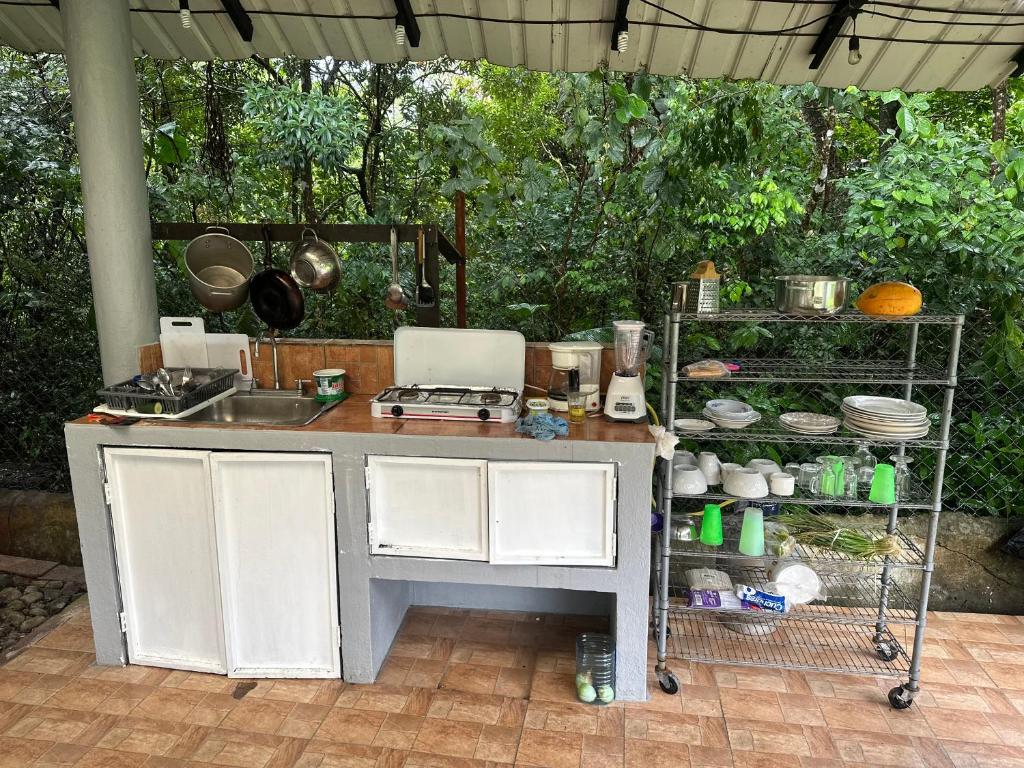 a kitchen with a counter with a sink and a stove at Hostal Lopez El Valle Cabañas in El Valle