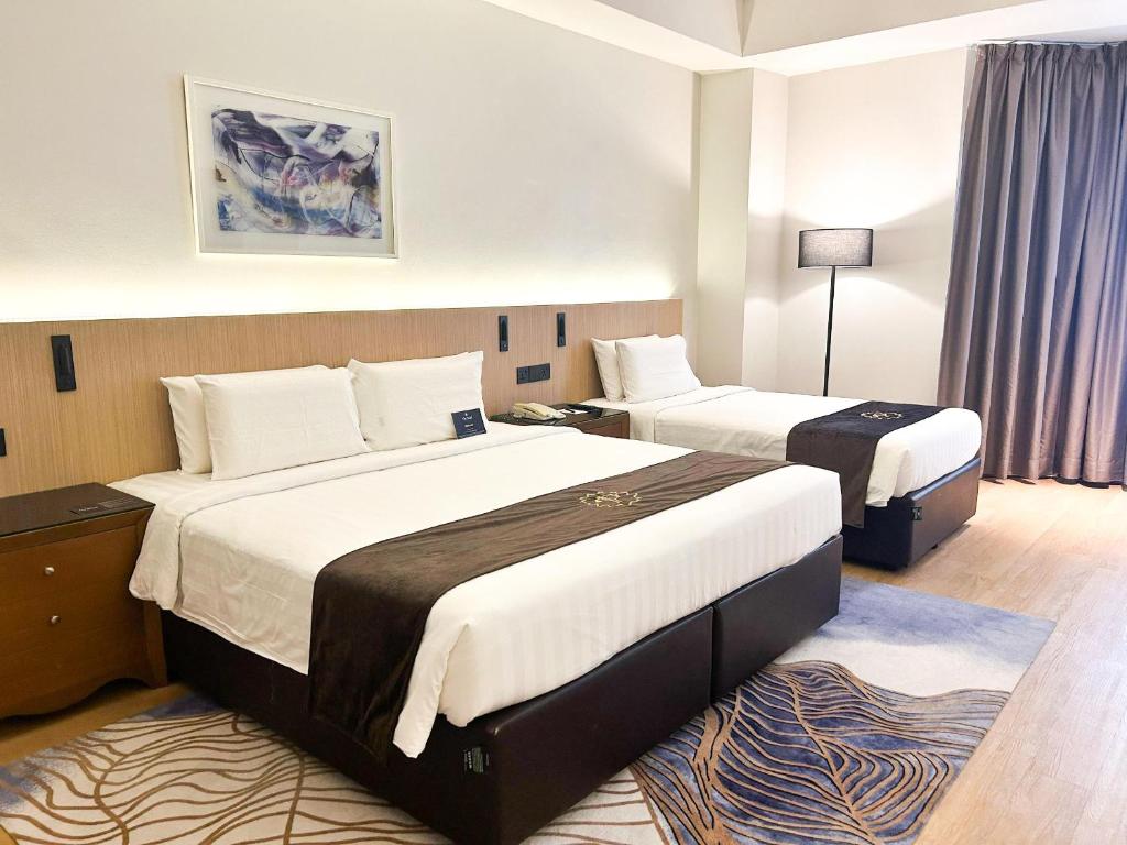 A twin room with two dressed beds, bedside storage, a floor lamp, and curtained windows.