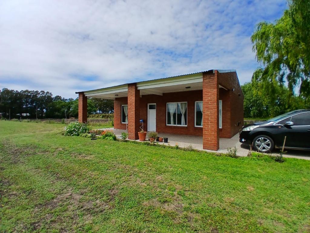 a small house with a car parked in front of it at Casa de campo in Mar del Plata