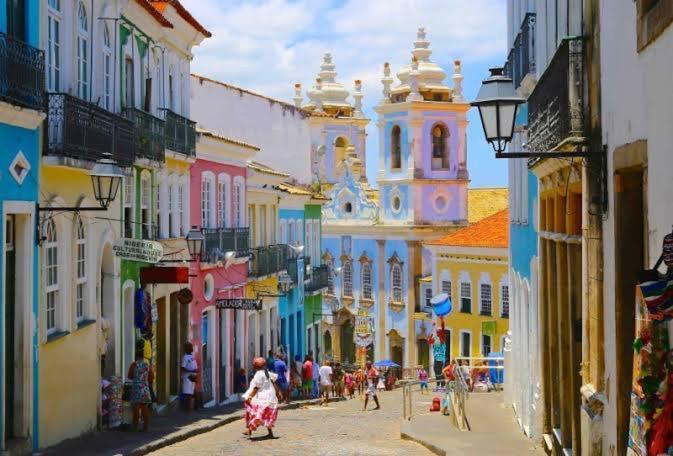 un gruppo di persone che camminano per una strada con edifici di Mini Casa - Orla - 8 Janelas Vista Mar! a Salvador