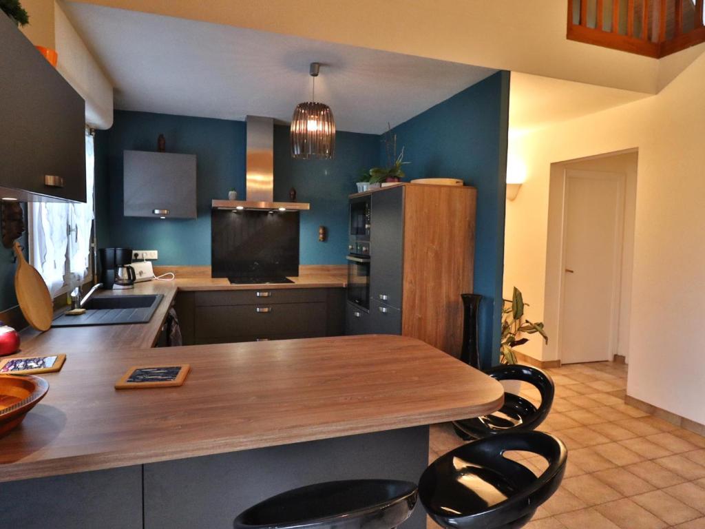 eine Küche mit einem Holztisch und einigen blauen Wänden in der Unterkunft Maison confortable 3 chambres, jardin, proche plages & bourg, WiFi, parking - FR-1-813-15 in Groix
