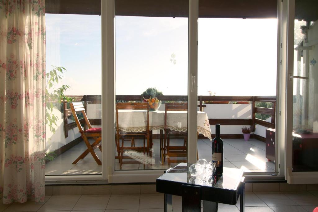 a living room with a table and a view of a balcony at Apartment Ruža 2021 in Premantura
