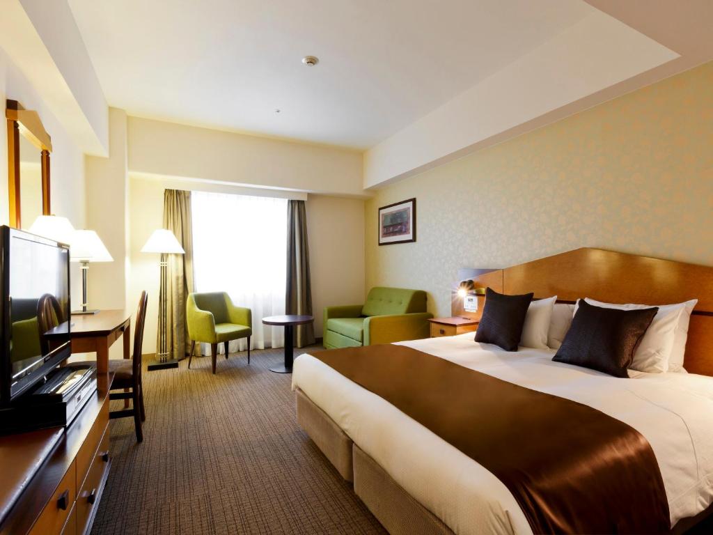 una camera d'albergo con un grande letto e una TV di Hotel Resol Gifu a Gifu