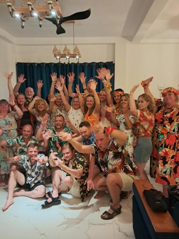 Un grupo de personas posando para una foto con las manos en el aire. en Bluesafiya lodge, en Matara