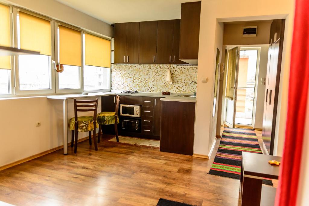 cocina con armarios marrones, mesa y sillas en Apartment Leonardo Da Vinci, en Plovdiv