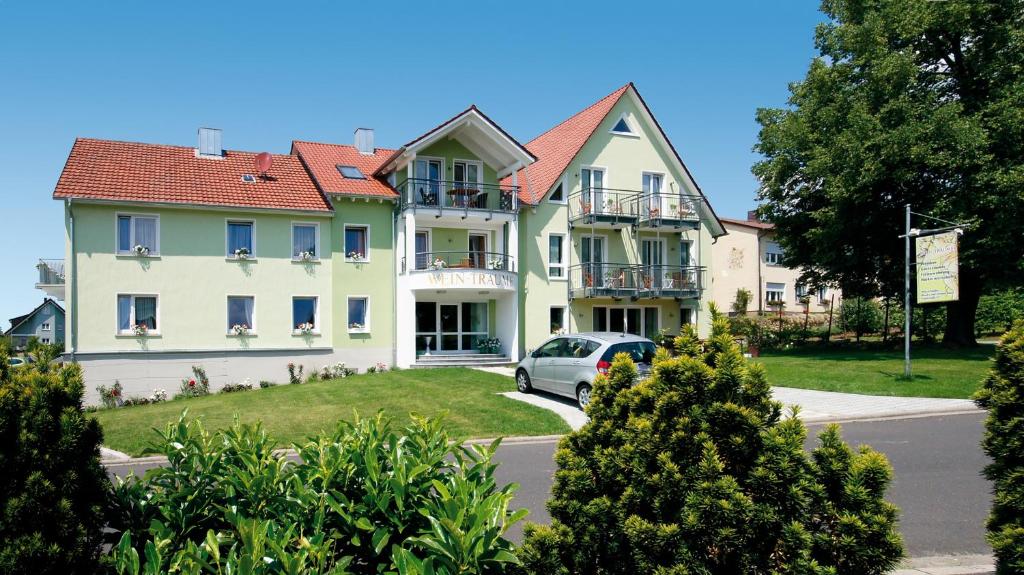 une grande maison avec une voiture garée devant elle dans l'établissement Wein-Träume, à Thüngersheim