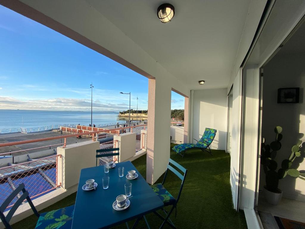 - une table bleue sur un balcon avec vue sur l'océan dans l'établissement Appartement rénové face plage, max 4 pers, terrasse - FR-1-709-81, à Fouras