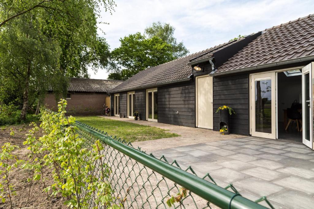 een huis met een hek ervoor bij De Gemoedelijkheid in Nuenen