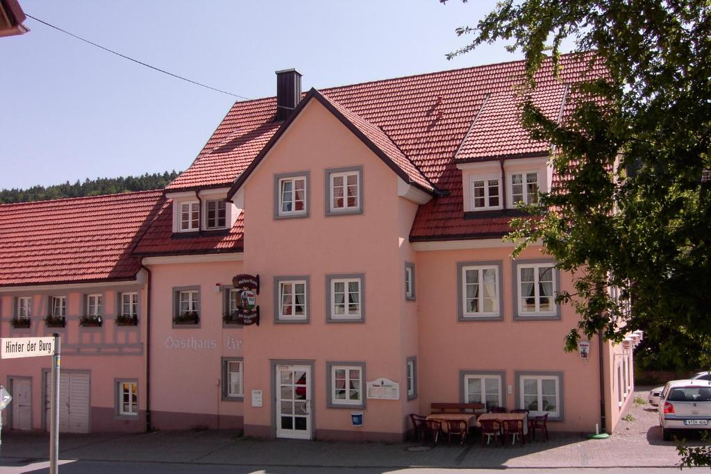 um edifício cor-de-rosa com uma mesa à frente. em Gasthaus Kranz em Lausheim