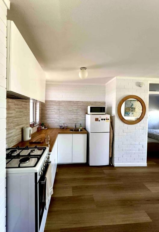 a kitchen with a stove and a white refrigerator at Right in Fremantle in Fremantle