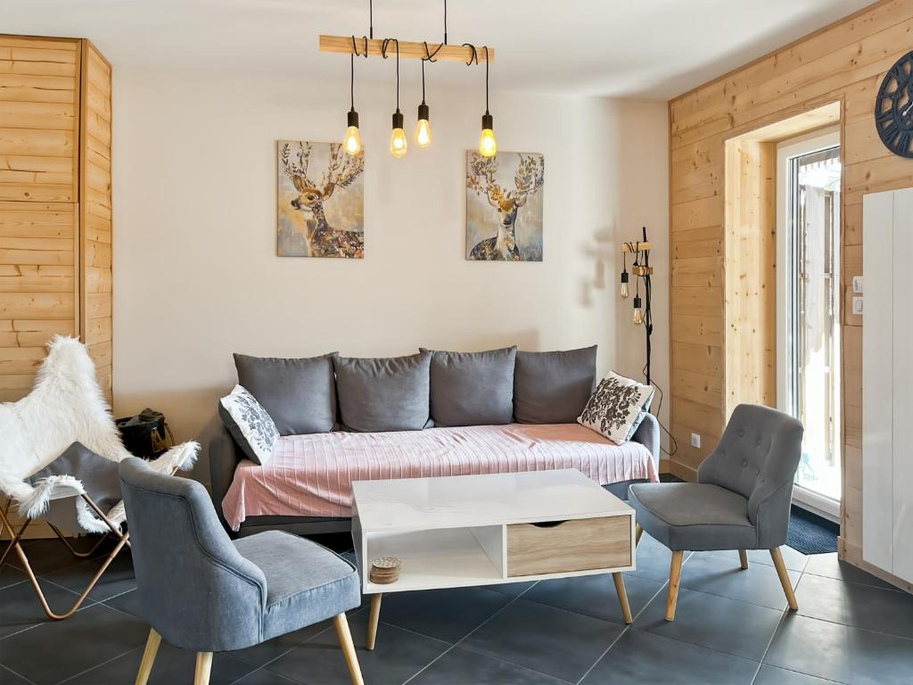 a living room with a couch and two chairs at Chalet les Estives au pied des pistes, le lioran, terrasse, 2 chambres, 4 lits in Laveissière