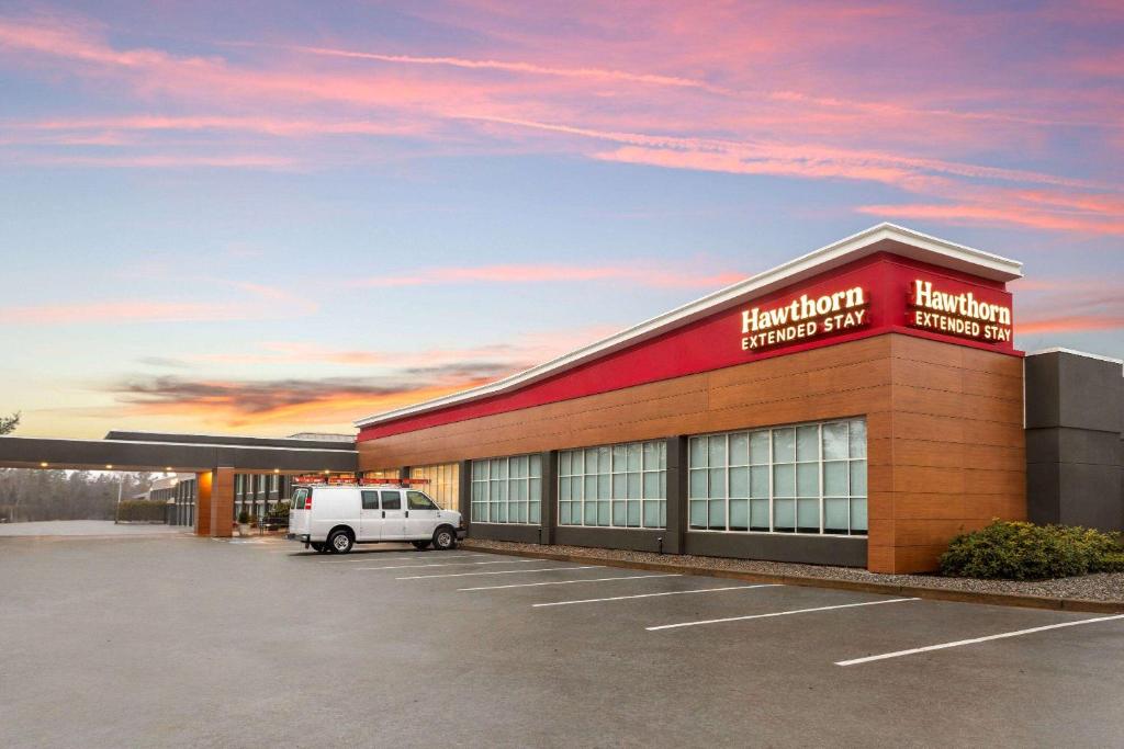 a building with a van parked in a parking lot at Hawthorn Extended Stay by Wyndham Ellsworth Bar Harbor in Ellsworth