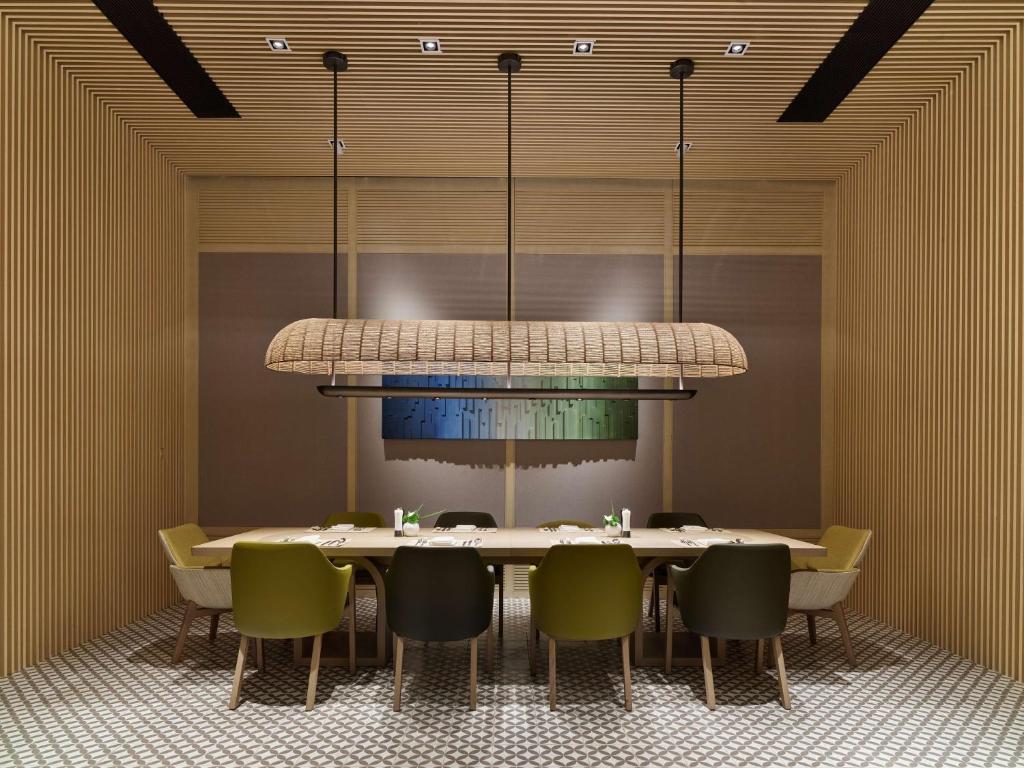 a dining room with a table and chairs under a chandelier at Hilton Shanghai Hongqiao International Airport in Shanghai