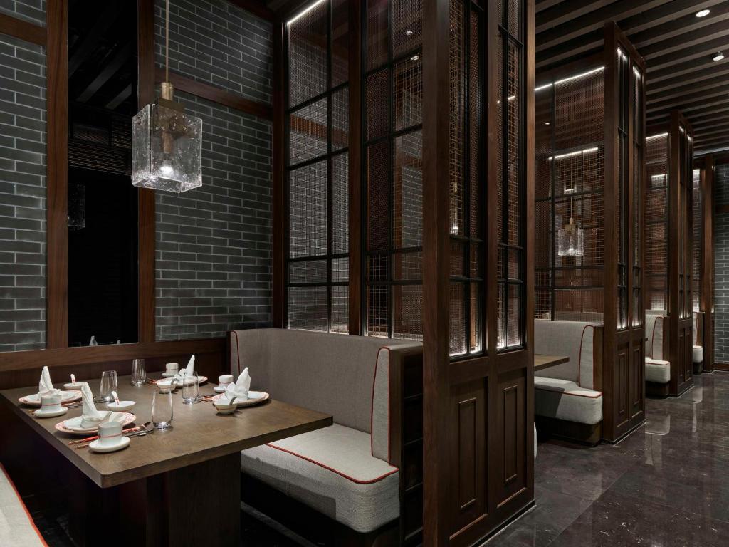 a dining room with a table and chairs and windows at Hilton Shanghai Hongqiao International Airport in Shanghai