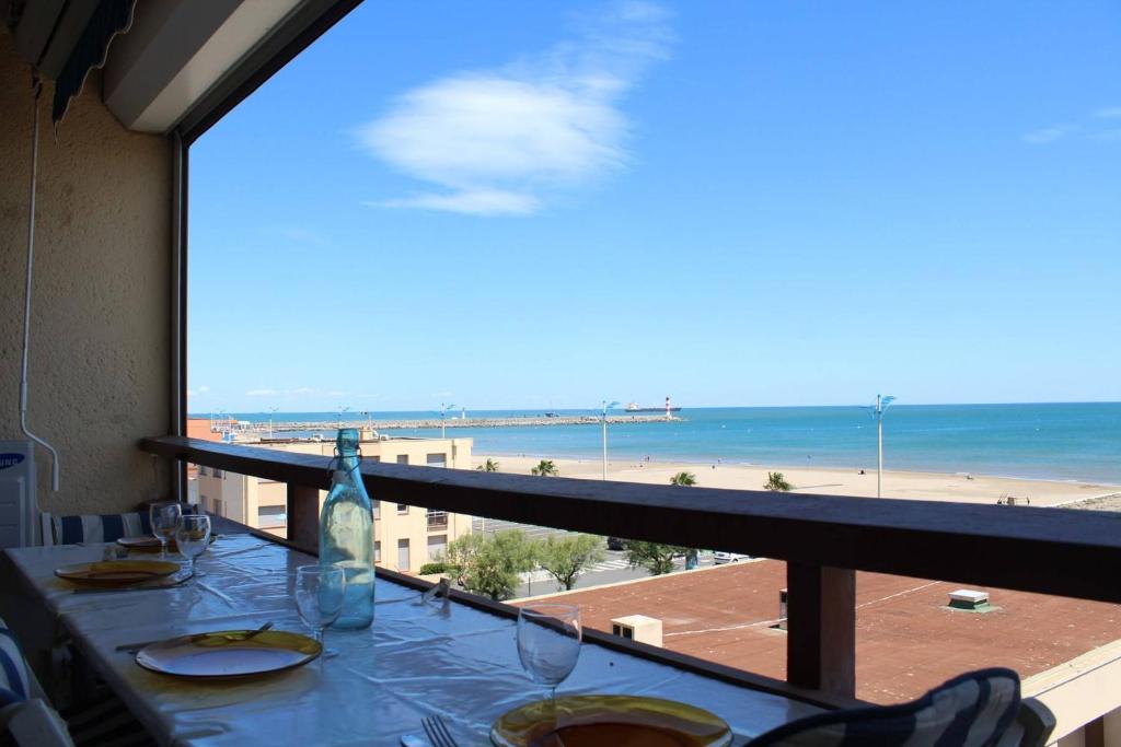 - une table avec des verres à vin et une vue sur la plage dans l'établissement Appartement 2 pièces PORT LA NOUVELLE PN590-046, à Port-la-Nouvelle