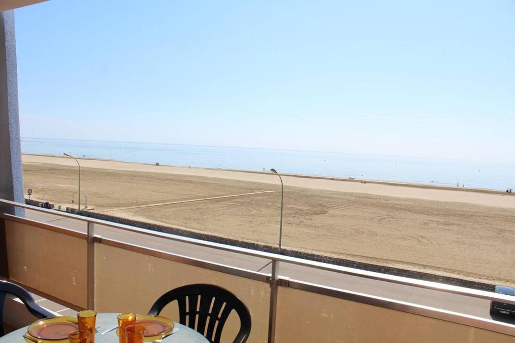 une table et des chaises avec vue sur la plage dans l'établissement Appartement 3 pièces PORT LA NOUVELLE PN210-064, à Port-la-Nouvelle
