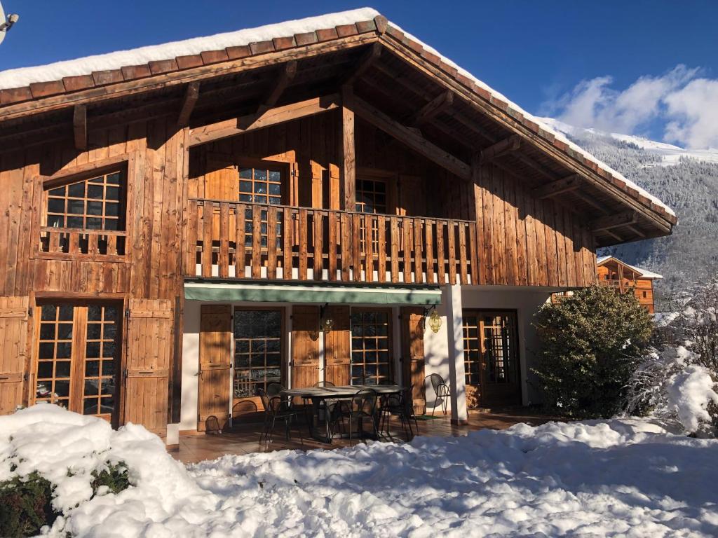 une cabane en rondins avec une table dans la neige dans l'établissement Chalet Cleo - charmant chalet 180 m2 avec vue montagne, à Samoëns