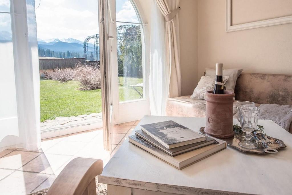 salon ze stołem z książkami i oknem w obiekcie Villa Toscana Boutique w Murzasichlu