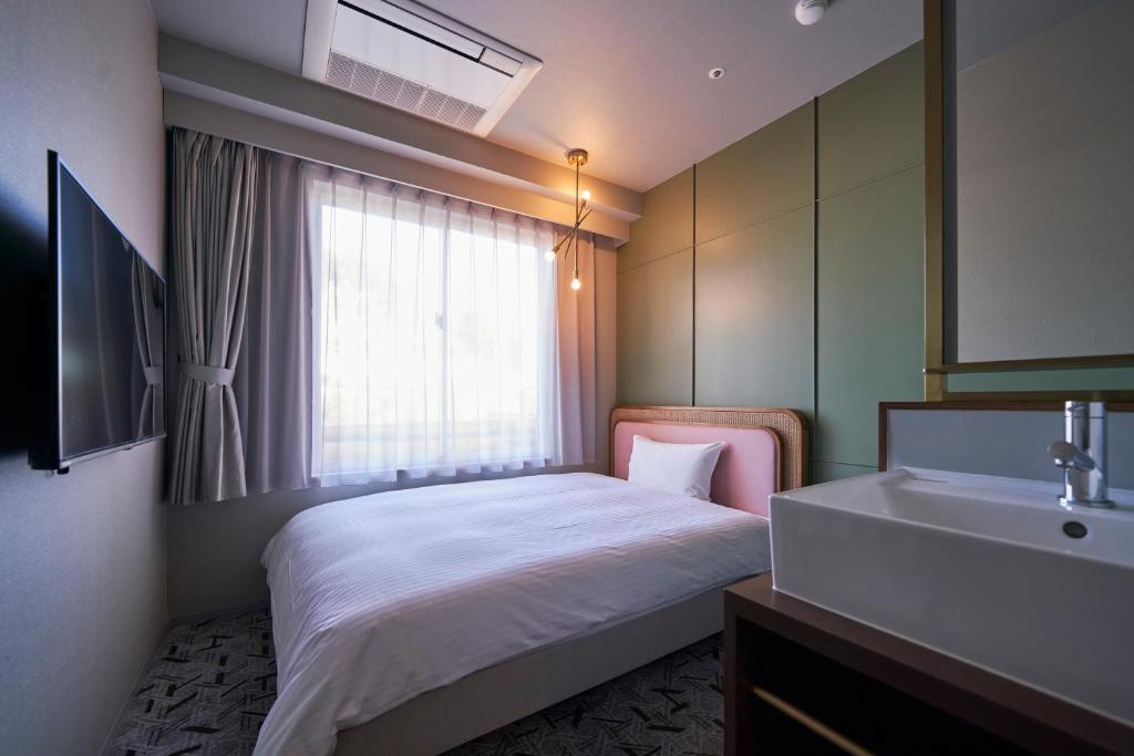 Postel nebo postele na pokoji v ubytování Mito Sannomaru Hotel