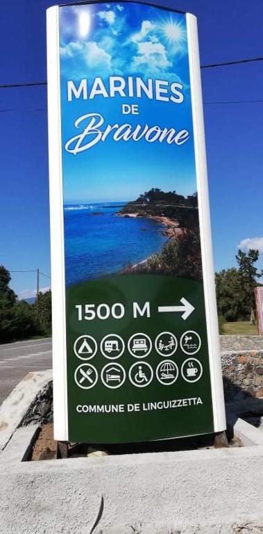 un panneau sur le côté d'une route à côté d'une plage dans l'établissement Appartement T2 bord de mer Corse, à Linguizzetta