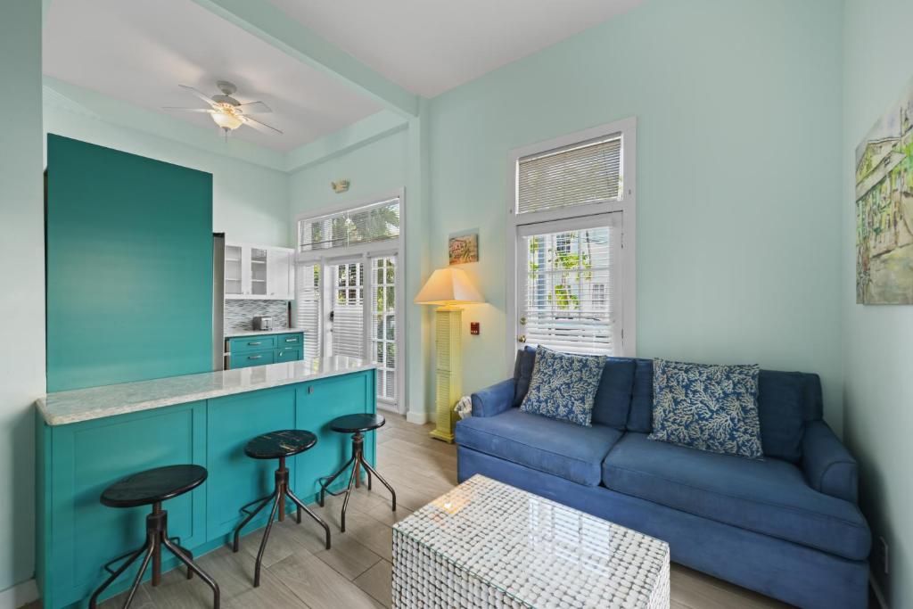 a living room with a blue couch and bar with stools at La Casa De Luna in Key West