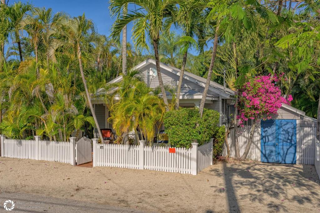 a house with a white fence and palm trees at Royal Escape in Key West