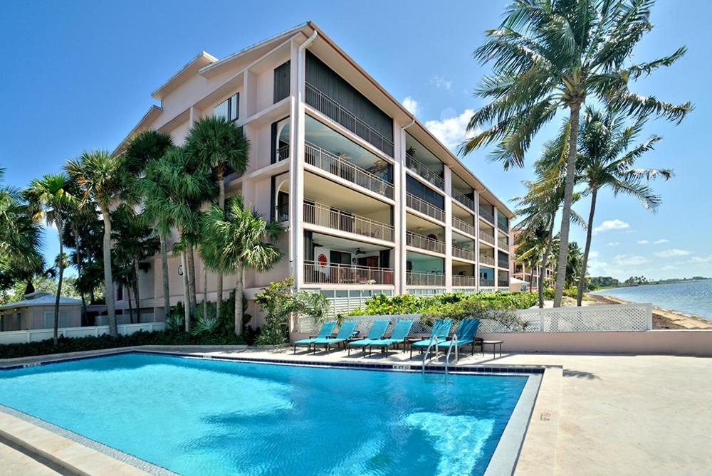 a building with a swimming pool next to a resort at Beach Club Shangra La 206 in Key West