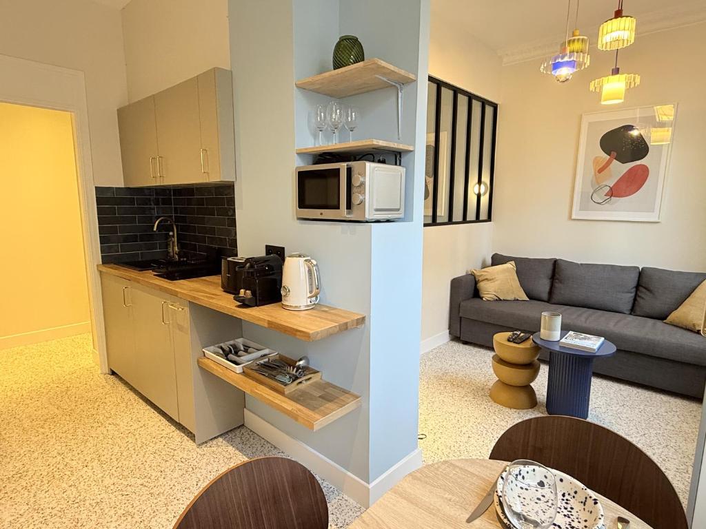 a kitchen and a living room with a couch at Charming flat - 4 guests - 5 min from Metro and Canal in Pantin