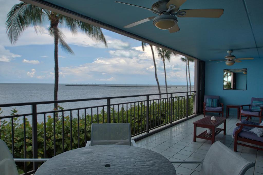 a balcony with a table and chairs and the ocean at Beach Club Siesta 104 in Key West