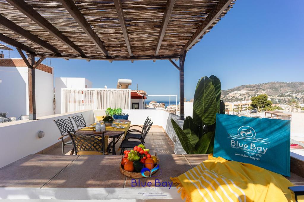 una mesa con fruta en el balcón con una caja azul en The Yellow One, en La Herradura