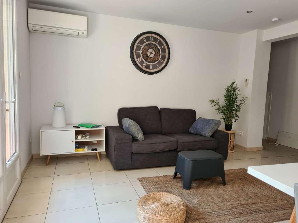 un salon avec un canapé et une horloge au mur dans l'établissement Appart 3 pièces 4 couchages BANYULS SUR MER BN440-001, à Banyuls-sur-Mer