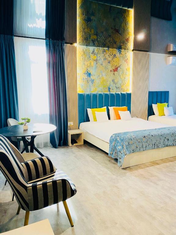 a bedroom with two beds and a chair and a table at HOTEL MAREA NEAGRA Mamaia in Mamaia