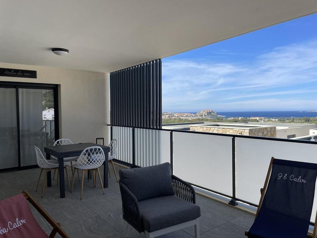un balcon avec une table et des chaises et une vue sur l'océan dans l'établissement T3 vue panoramique sur la baie de Calvi, à Calvi