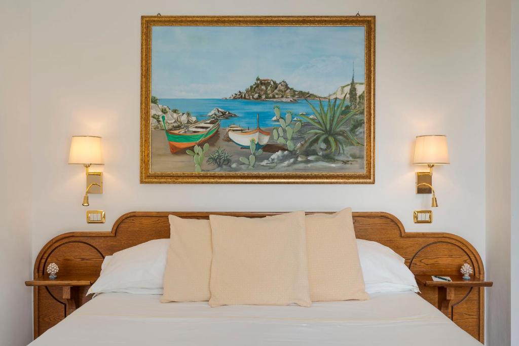 een slaapkamer met een bed met een schilderij aan de muur bij Hotel Villa Schuler in Taormina